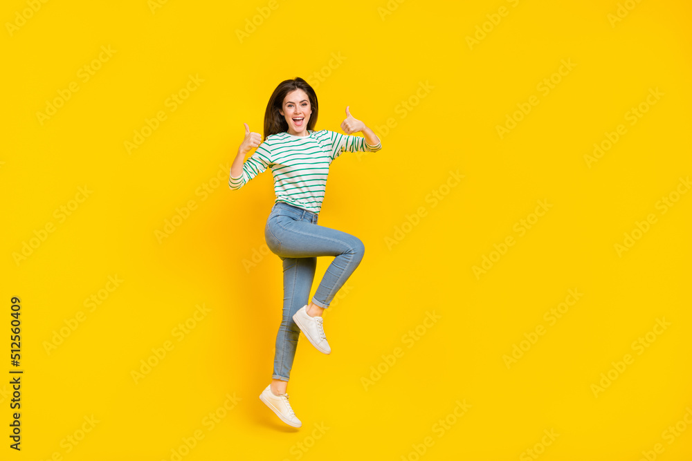 Full size photo of cheerful attractive charming girl show thumb-up promote product isolated on yellow color background Full size photo of cheerful attractive charming girl show thumb-up promote product isolated on yellow color background