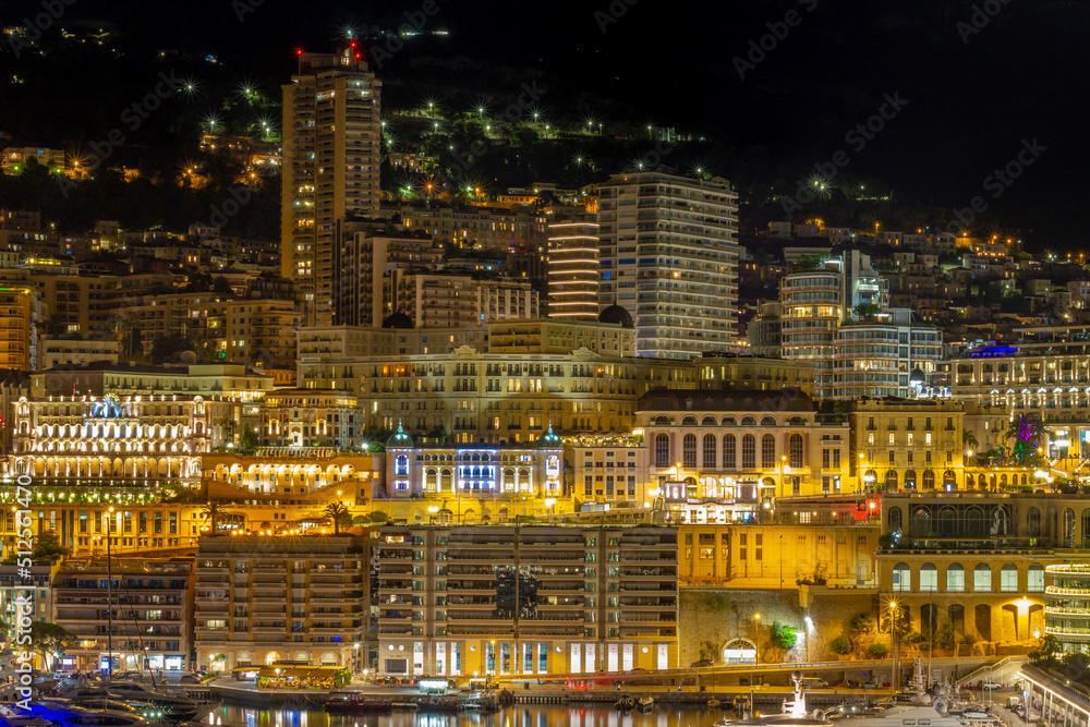 Monaco principality at night, luxury yachts at Port Hercules waterfront