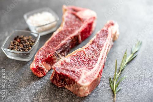 Raw steak "New York" on the bone with rosemary and spices. 