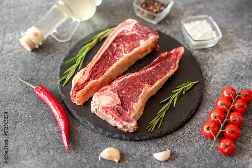 Raw steak "New York" on the bone with rosemary and spices. 