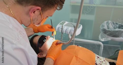 professional stomatologist doing dental restoration for patient in clinic photo