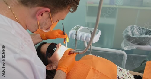professional stomatologist doing dental restoration for patient in clinic