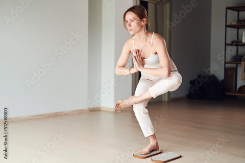 Practice of standing on nails. Woman stand on sadhu board in yoga studio. Concept on healthy lifestyle.