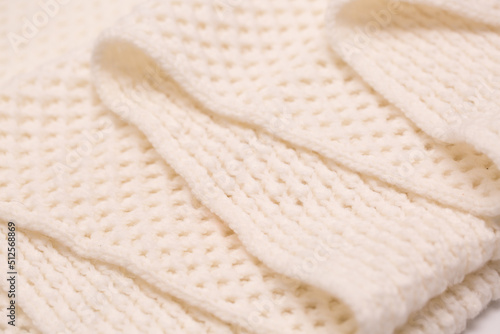 Knitted surface of woolen things as a background. Close-up of soft white texture of knitted patterns. Warm winter clothes. Background textile surface with copy space for text.