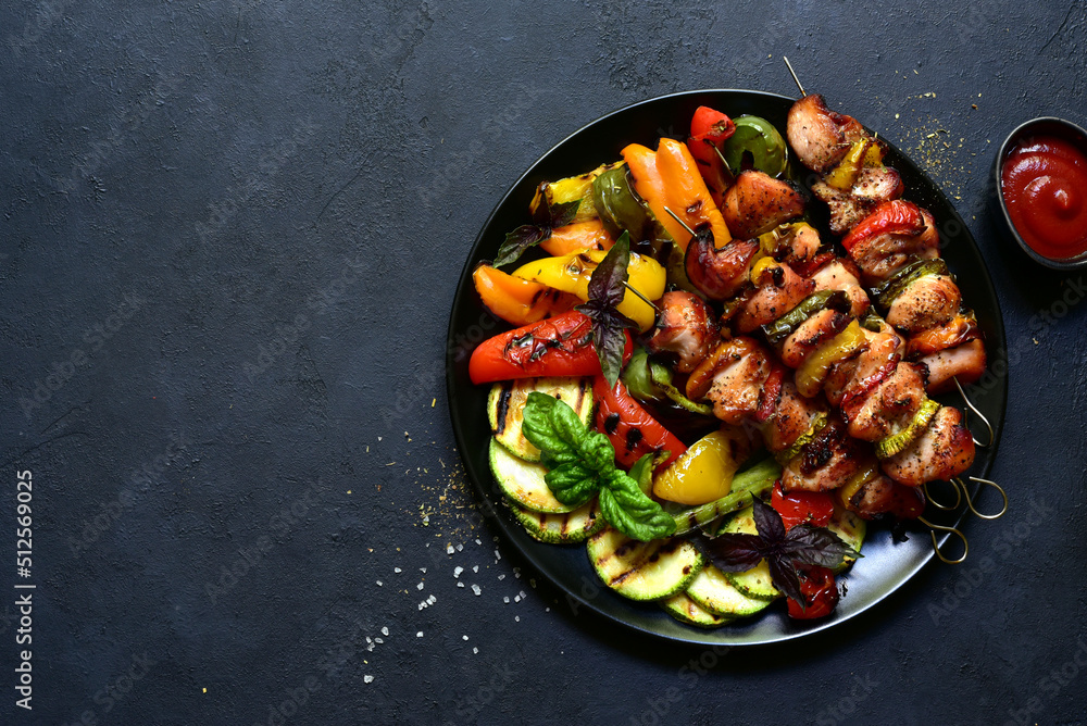 Chicken kebab skewers with grilled vegetables. Top view with copy space.
