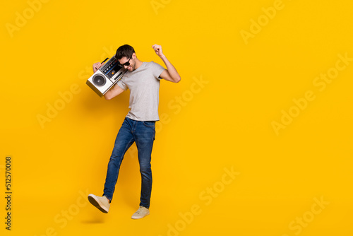 Full length body size view of attractive cool guy dancing listening hip hop isolated over vivid yellow color background