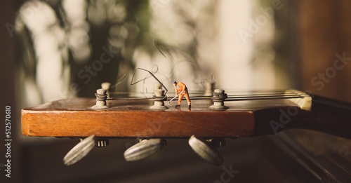 Obraz na plátně The technician worker figure fixing old guitar strings.