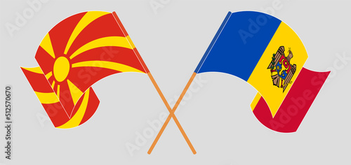 Crossed and waving flags of North Macedonia and Moldova