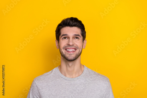 Photo of impressed brunet young guy look up wear trend cloth isolated on yellow color background