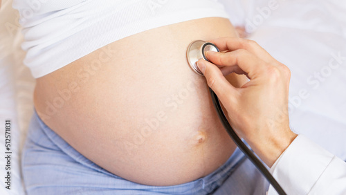 Pregnant doctor hospital. Medical clinic for pregnancy consultant. Doctor examining pregnancy woman belly holding stethoscope. Pregnancy, medicine health care concept.