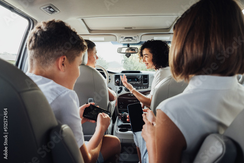Fotografie Happy Four Members Family Traveling by Minivan Car, Mother and Father with Two T