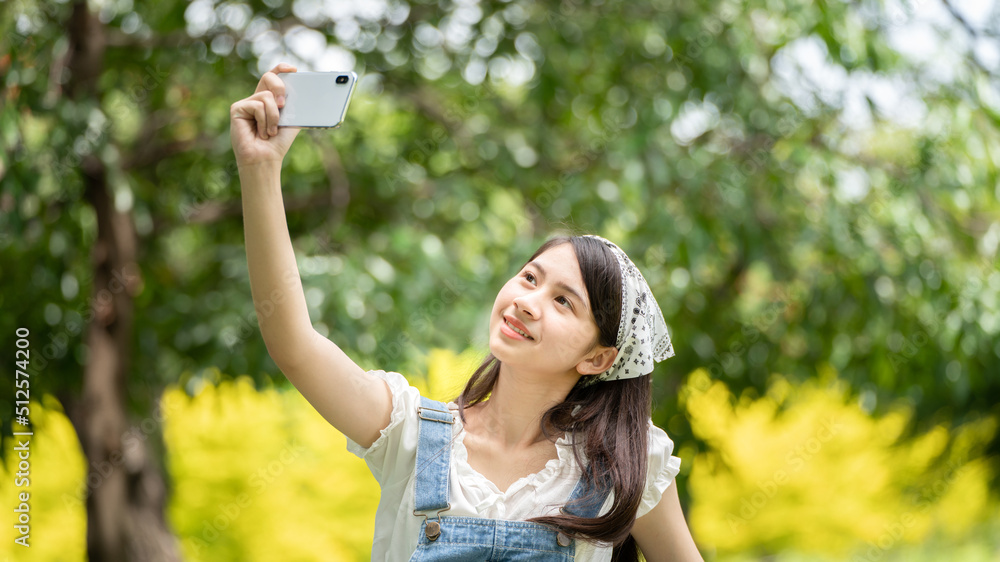 Thoughtful smile woman in park using smart phone for selfie photo , Portrait of a young charming business woman checking online Business work on her smart phone outdoors in the park Thoughtful smile woman in park using smart phone for selfie photo , Portrait of a young charming business woman checking online Business work on her smart phone outdoors in the park