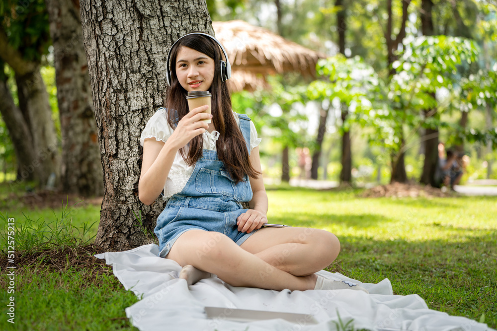 Young stylish woman drinking coffee and using paper cup and to go in a park, young people female hand holding paper cup of take away drinking coffee on natural morning Young stylish woman drinking coffee and using paper cup and to go in a park, young people female hand holding paper cup of take away drinking coffee on natural morning