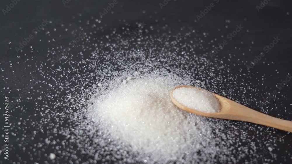 granulated sugar. sugar with wooden spoon on black background granulated sugar. sugar with wooden spoon on black background