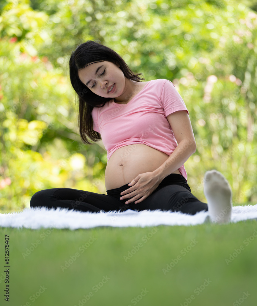 Pregnant woman touching belly in the City Park, Pregnant Relaxing and exercise, Beautiful tender mood photo of pregnancy Pregnant woman touching belly in the City Park, Pregnant Relaxing and exercise, Beautiful tender mood photo of pregnancy