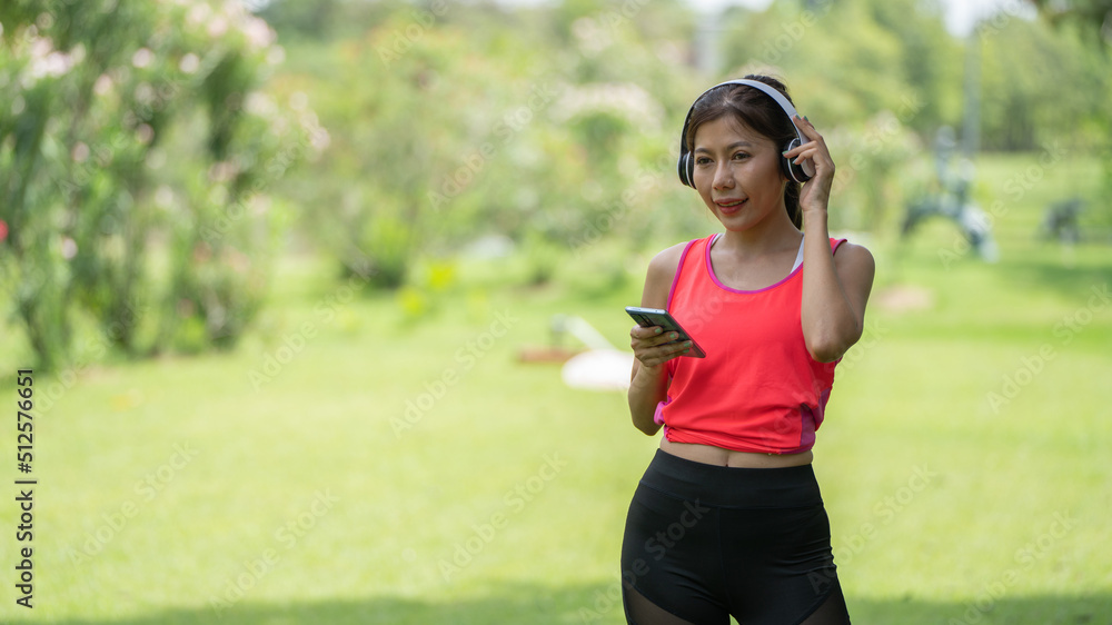 Beautiful young woman girl in beige shirt posing in Green city Park background , Smile girl Listening Music with Headphones feeling Touching Happiness. People lifestyle concept. Mock up copy space Beautiful young woman girl in beige shirt posing in Green city Park background , Smile girl Listening Music with Headphones feeling Touching Happiness. People lifestyle concept. Mock up copy space