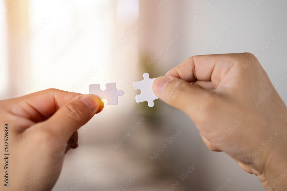 Closeup hand of woman connecting jigsaw puzzle with sunlight effect, Business solutions Closeup hand of woman connecting jigsaw puzzle with sunlight effect, Business solutions