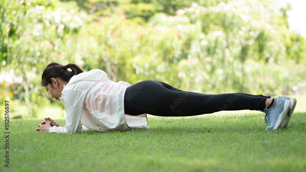 Healty Young female workout exercise before running or fitness training session in City Park. Healthy young woman warming up outdoors. She is stretching her arms at Garden park, Sports and activities Healty Young female workout exercise before running or fitness training session in City Park. Healthy young woman warming up outdoors. She is stretching her arms at Garden park, Sports and activities