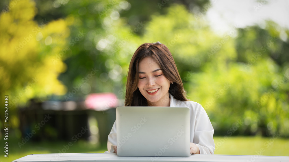 Thoughtful smile woman in park using smart digital tablet, Portrait of a young charming business woman checking online Business work on her smart tablet or labtop outdoors in the park on soft screen Thoughtful smile woman in park using smart digital tablet, Portrait of a young charming business woman checking online Business work on her smart tablet or labtop outdoors in the park on soft screen