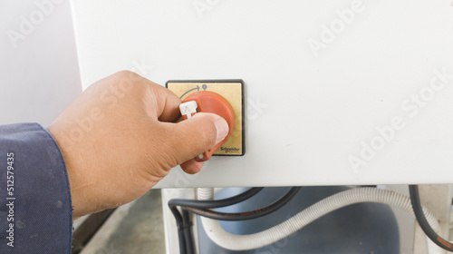 The man turning on main switch on panel control. photo