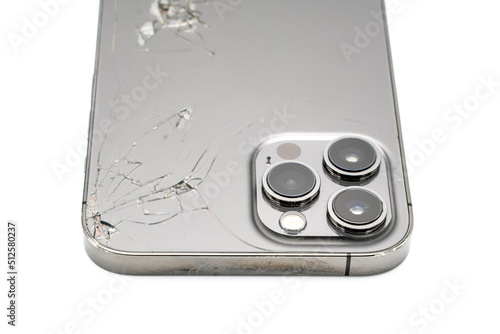 Close up of modern smartphone with broken back glass on white background.