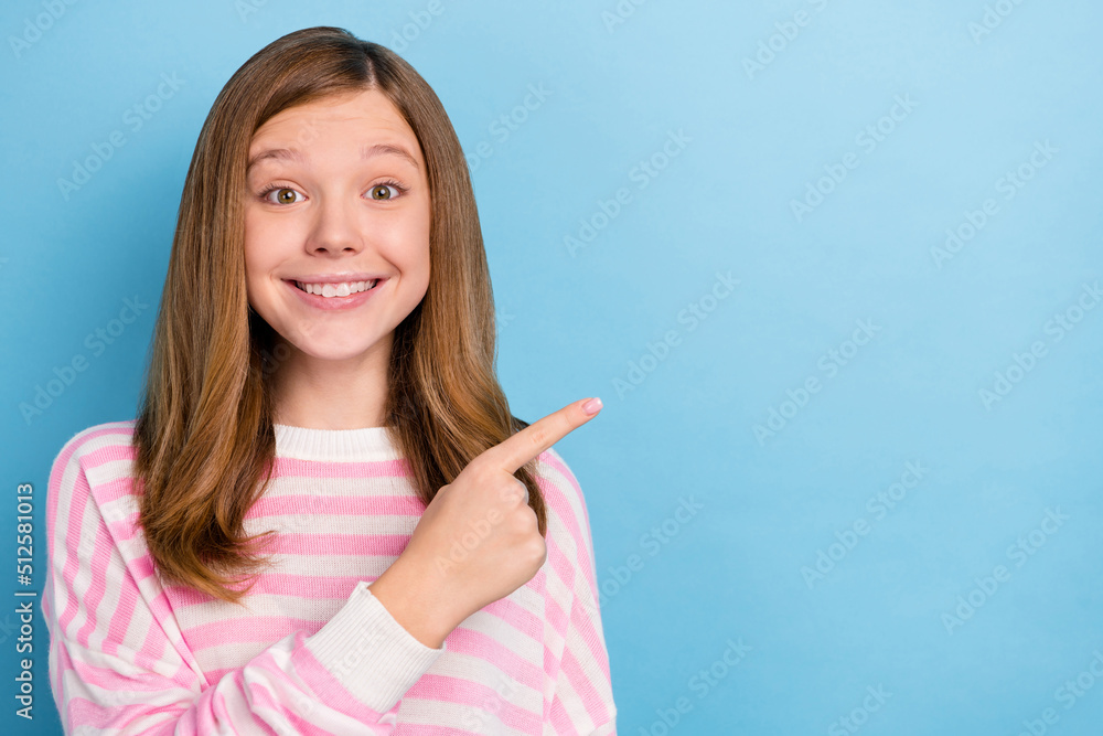 Photo of cute little girl show promo wear pink shirt isolated on blue color background Photo of cute little girl show promo wear pink shirt isolated on blue color background