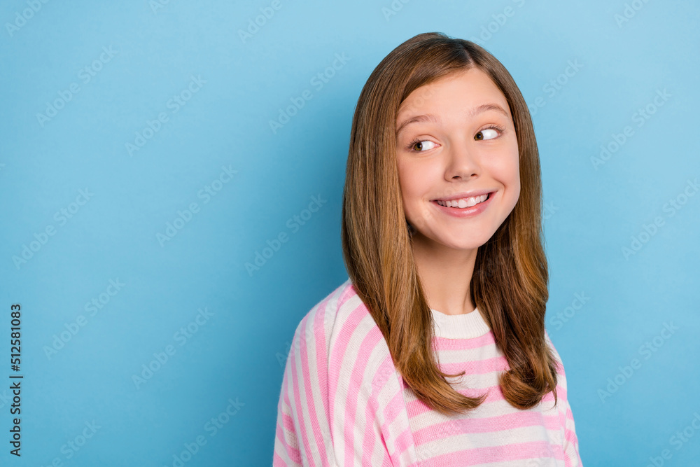 Portrait of adorable satisfied person toothy smile look interested empty space isolated on blue color background Portrait of adorable satisfied person toothy smile look interested empty space isolated on blue color background