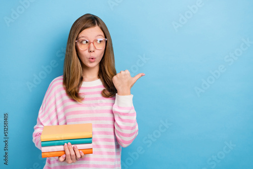 Portrait of impressed pupil look indicate thumb empty space isolated on blue color background