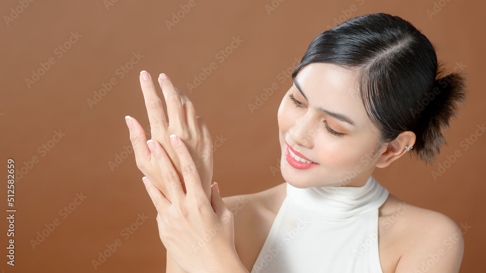 Close up young woman hand is applying cream over brown background , beauty skin care concept Close up young woman hand is applying cream over brown background , beauty skin care concept