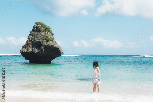 沖縄の海と石を見る女性 © 崇史 野中