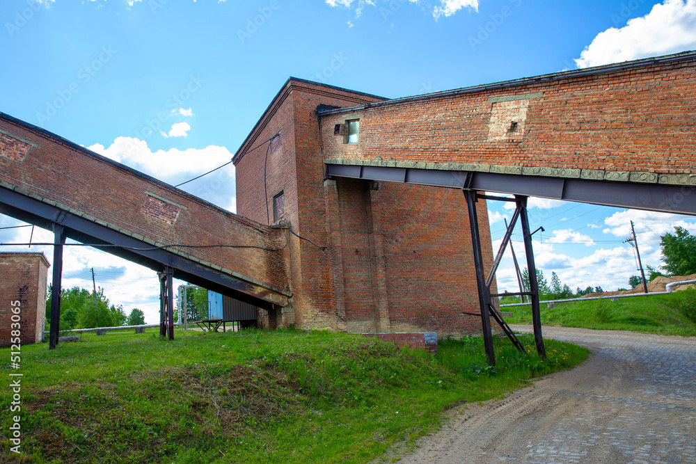industrial brick building complex with white clouds in the background