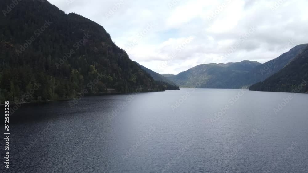 A panning drone video over a lake between two mountains on a sunny day. Located in Parksville, Vancouver Island, Canada. A panning drone video over a lake between two mountains on a sunny day. Located in Parksville, Vancouver Island, Canada.