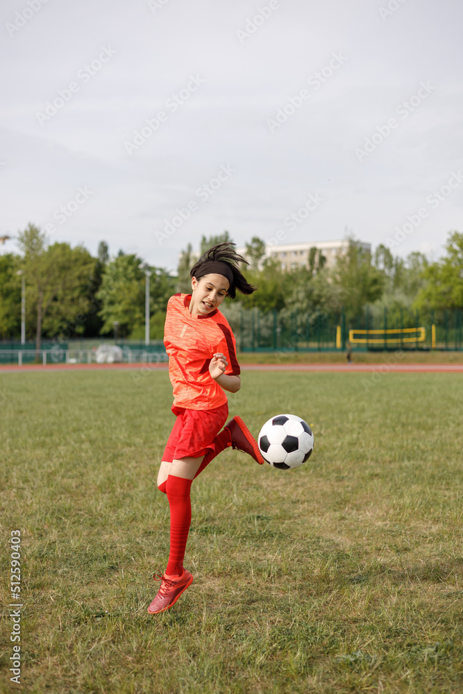 Soccer player back to kick a ball in the air