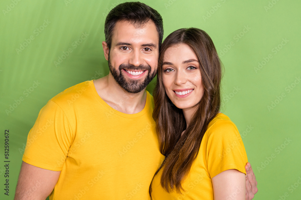 Photo of two cheerful positive partners cuddle toothy beaming smile isolated on green color background