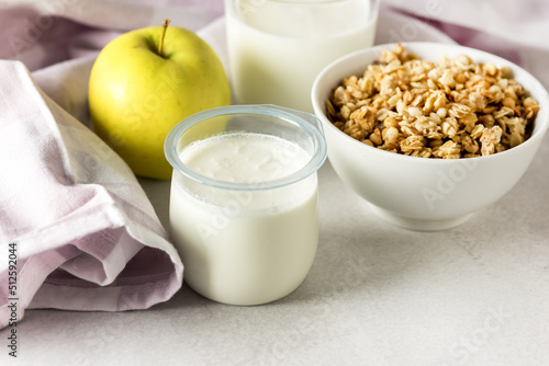 Portions of Fresh Natural Homemade Organic Yogurt Bowl of Granola Raw Apple Napkin Glass of Milk Breakfast Concept