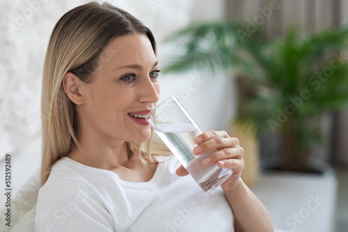 Healthy young lady drinking fresh water after waking up