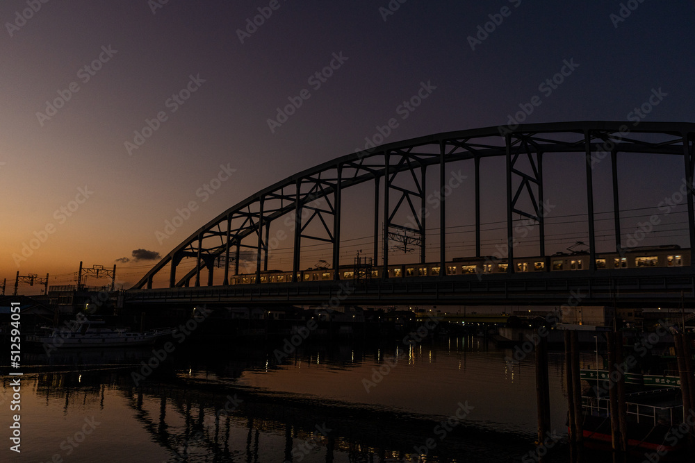 鉄橋を走る電車と夕暮れ