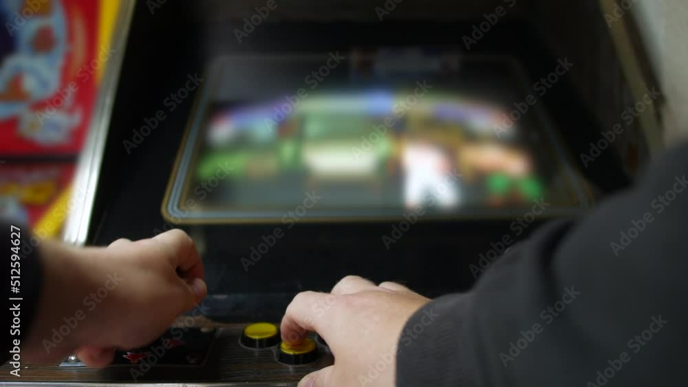 Close up of man playing a video game a retro vintage arcade machine. He ...