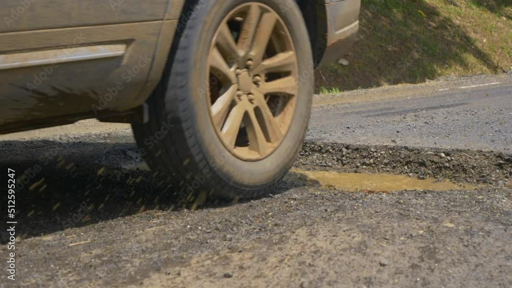 Gouges On Highway Vidéo Stock SLOW MOTION, CLOSE UP, DOF: Murky water splashes as car ...