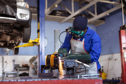 Mid adult african american female welder wearing protective workwear while wielding in workshop photo