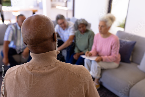 African american senior man sharing his emotions with multiracial friends in retirement home