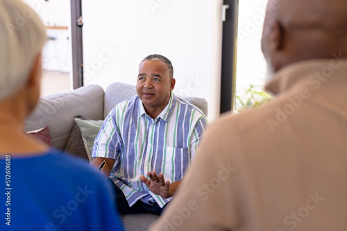 Caucasian senior man sharing his emotions with multiracial friends in group therapy session