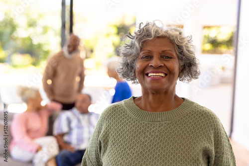 Portrait of smiling african american senior woman standing with multiracial friends in background