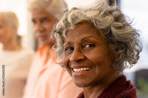 Close-up portrait of cheerful african american senior woman with multiracial friends in nursing home
