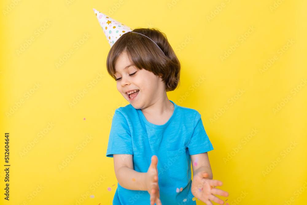 Handsome Little birthday boy in blue shirt and hat with balloons, yellow background, happy birthday Handsome Little birthday boy in blue shirt and hat with balloons, yellow background, happy birthday