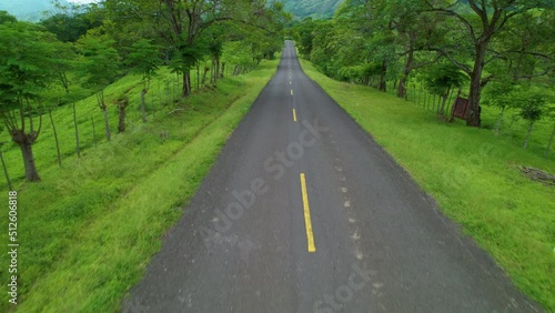 Wallpaper Mural AERIAL: Flying above the empty asphalt road crossing the lush green countryside of Central Panama. Scenic shot from above of the vast tropical nature surrounding a country road in Latin America. Torontodigital.ca