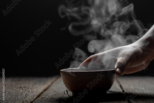 Steam of hot soup with smoke in a soup wood bowl bowl on wood table. Concept food Japanese or Chinese background