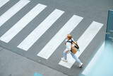 girl crossing crosswalk and going to school outdoors in city