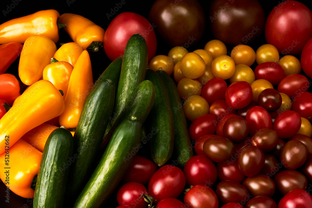 Set of delicious tomatoes, cucumbers and peppers on a black background Set of delicious tomatoes, cucumbers and peppers on a black background