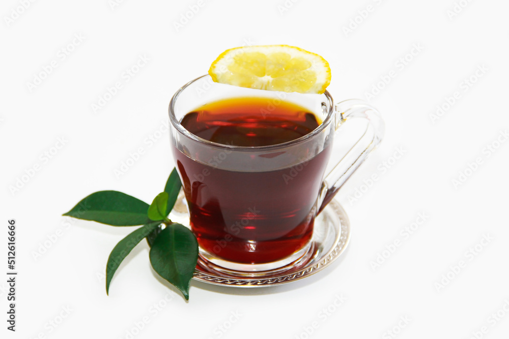 black tea in a transparent mug with a slice of lemon and green leaves black tea in a transparent mug with a slice of lemon and green leaves